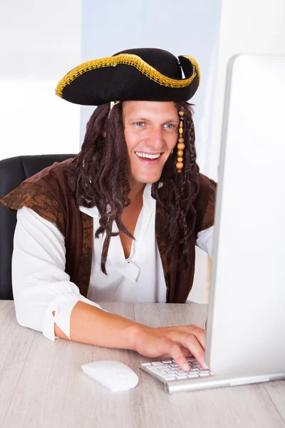 Feliz pirata usando la computadora —  Fotos de Stock