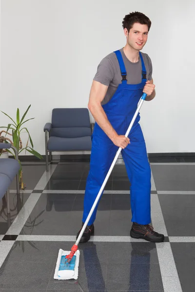 Homem limpando o chão — Fotografia de Stock