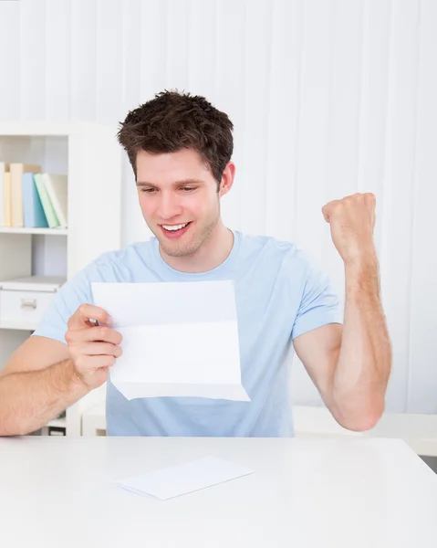 Homem feliz olhando para o papel — Fotografia de Stock