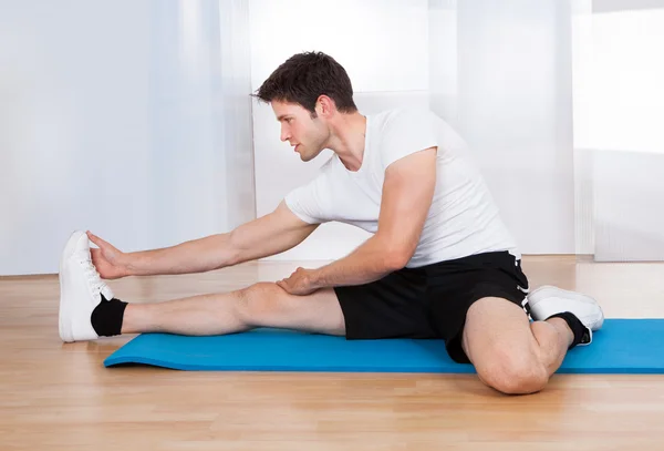 Happy Man Doing Stretching Exercise Stock Photo