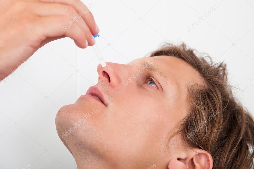 Young Man Using Nasal Spray