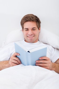 Genç adam kitap okuyor.