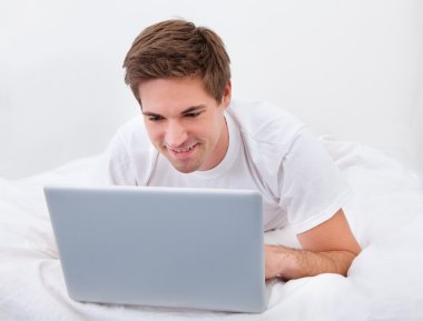 Genç adam dizüstü bilgisayar kullanıyor