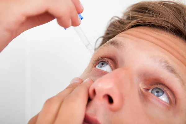 Young Man Putting Eye Drops In His Eyes — Stock Photo, Image