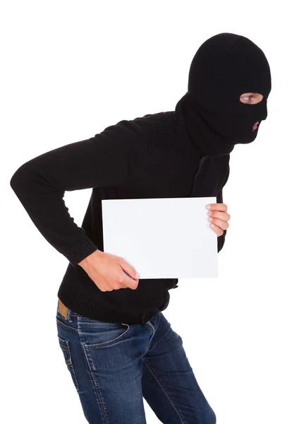 Ladrón sosteniendo placa en blanco — Foto de Stock