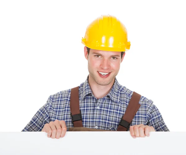 Hombre trabajador sosteniendo cartel en blanco — Foto de Stock