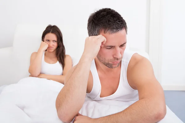Разочарованная пара на кровати — стоковое фото
