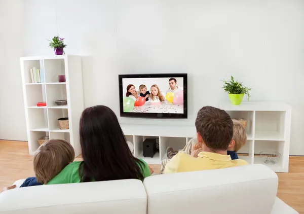 Familia joven viendo la televisión Imagen De Stock