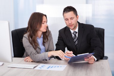 ofis masa başında çalışan panoya bakarak iş adamları