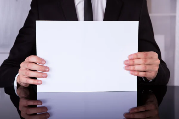 Empresário mostrando espaço em branco na mesa — Fotografia de Stock