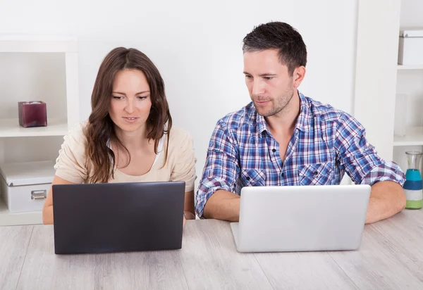 Casal jovem grave usando laptop — Fotografia de Stock