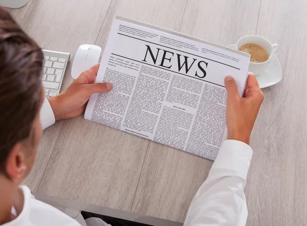 Man leest de krant met koffie op Bureau — Stockfoto