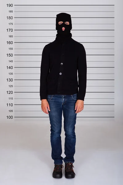 Włamywacz stojące przed policja spisu — Zdjęcie stockowe