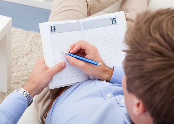 Young man writing in diary — Stock Photo, Image