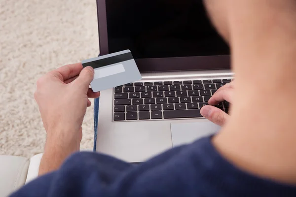 Person som innehar kreditkort med hjälp av bärbar dator — Stockfoto