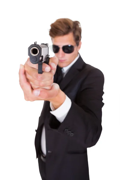 Мужской секретный агент, прицеливающийся с пистолетом — стоковое фото