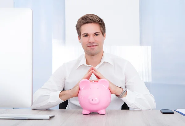 Homem de negócios segurando piggybank — Fotografia de Stock