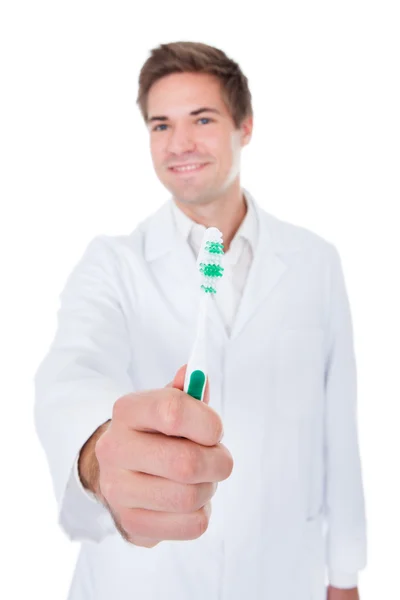 Dentista segurando escova de dentes — Fotografia de Stock