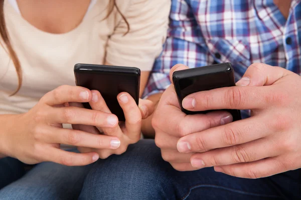 Pareja feliz usando el teléfono celular —  Fotos de Stock