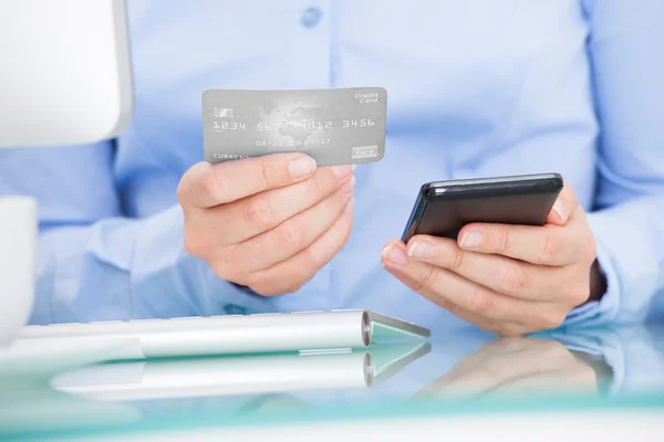 Femme d'affaires tenant téléphone portable et carte de crédit — Photo