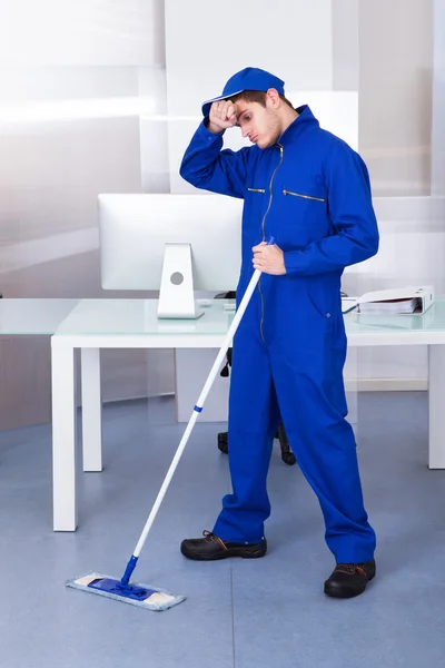 Unavený člověk čištění podlahy — Stock fotografie