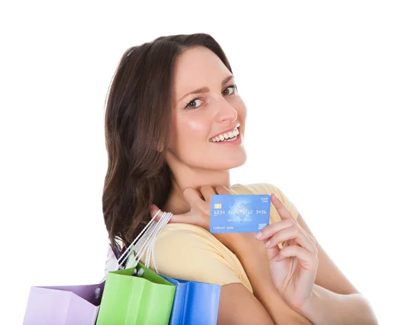 Женщина с сумками, держащая кредитную карту — стоковое фото