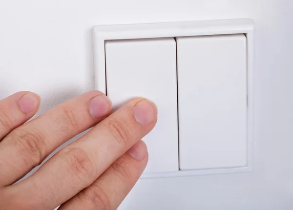 Mano presiona el interruptor de luz en la pared — Foto de Stock