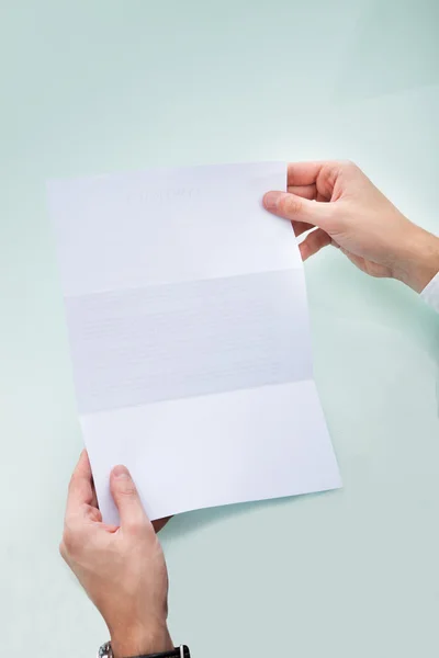 Mão da pessoa segurando papel em branco — Fotografia de Stock