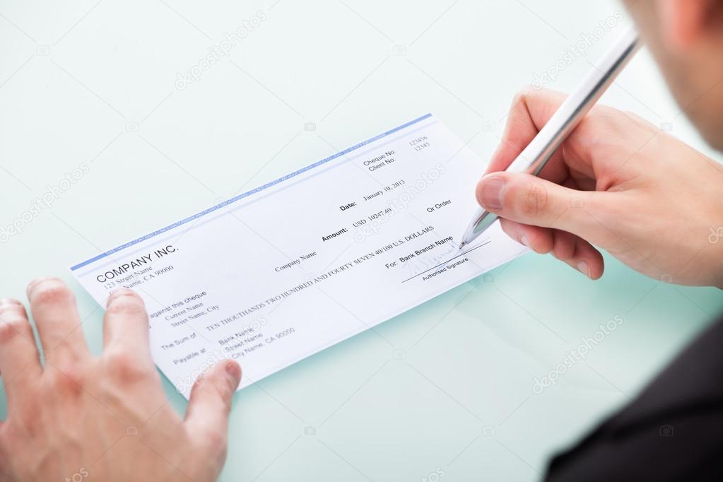 Businessman Signing On Cheque