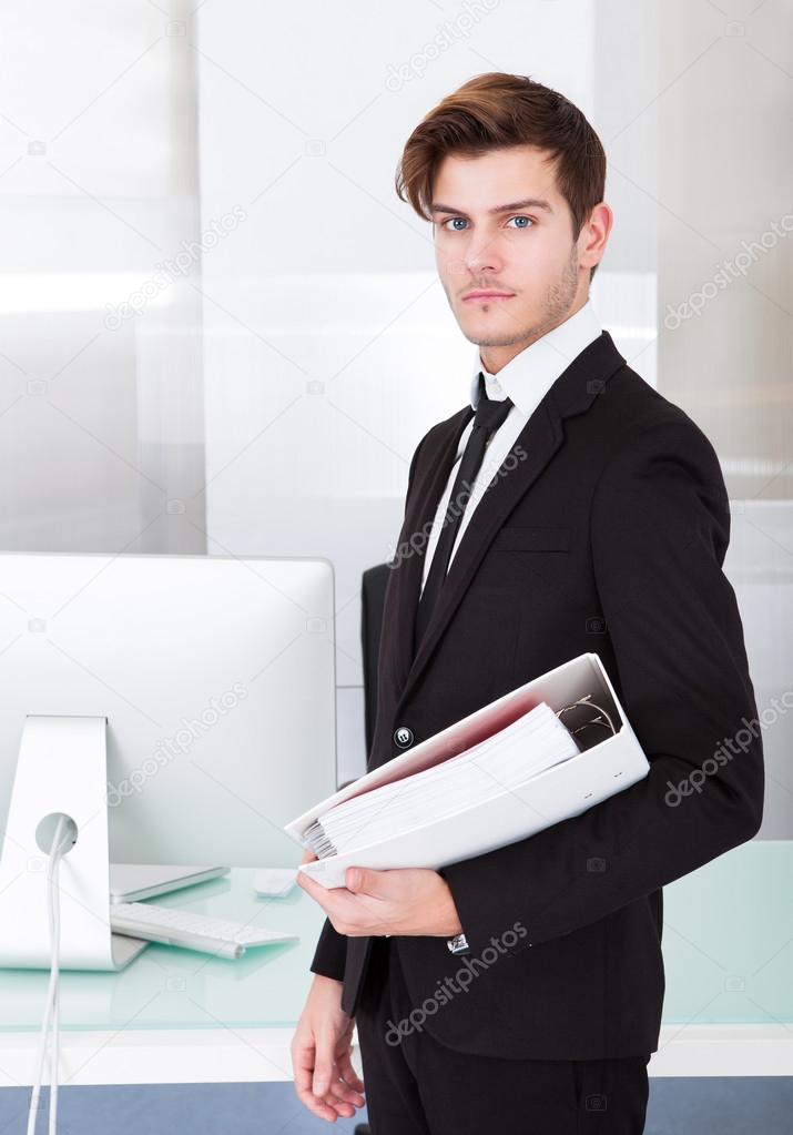 Young Businessman Holding Folder In Office