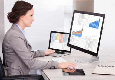 jonge zakenvrouw analyseren grafiek op computer