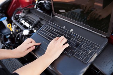 Hand Typing On A Computer In A Garage clipart