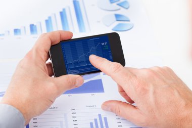 cep telefonundan işaret eden işadamı
