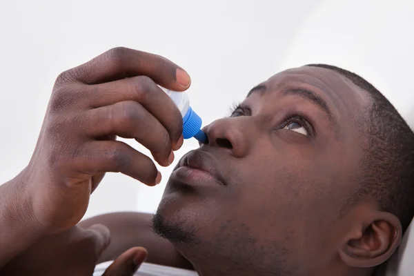 Homem africano com spray de nariz — Fotografia de Stock