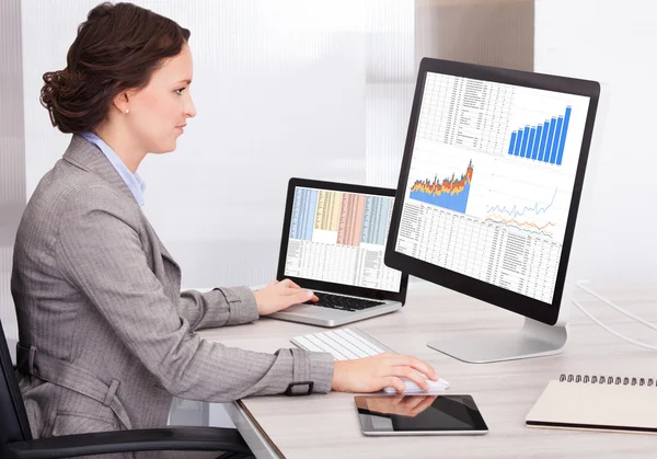 Junge Geschäftsfrau analysiert Graphik am Computer — Stockfoto