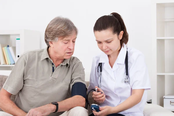 Medico che misura la pressione sanguigna del paziente — Foto Stock