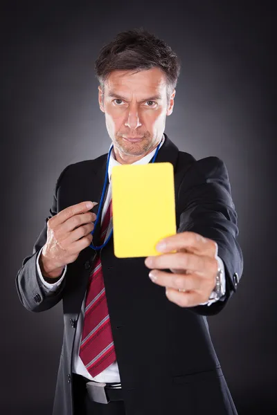 Homme d'affaires montrant carton jaune — Photo