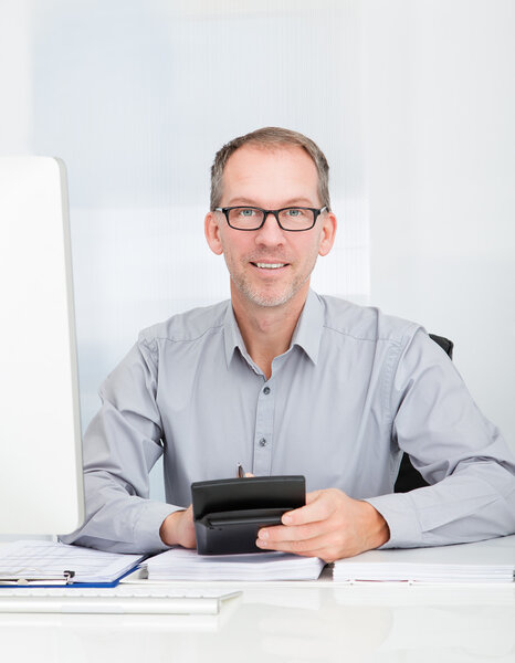 Бизнесмен с помощью калькулятора
