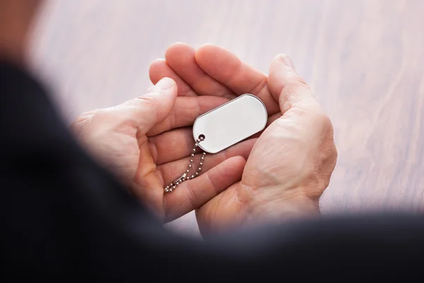 Businessman Hand On Wooden Table Holding Dog Tag — Stock Photo, Image