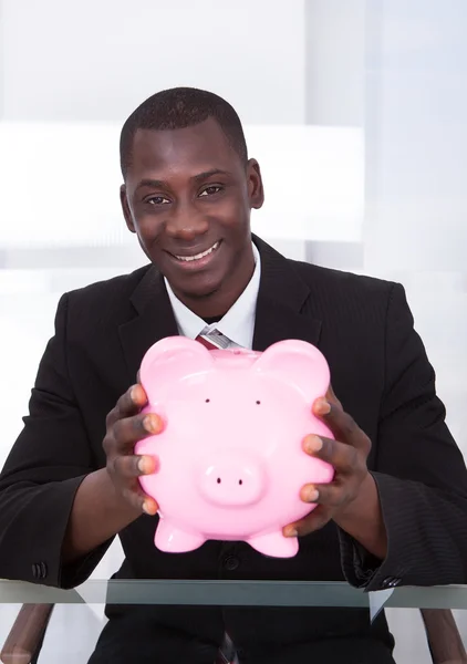 Forretningsmann Holding Piggybank – stockfoto