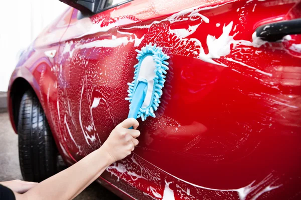 Mão segurando escova sobre carro — Fotografia de Stock