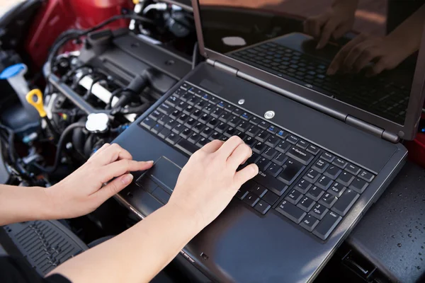 Hand att skriva på en dator i ett garage — Stockfoto