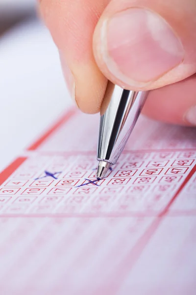 Número de marcação da pessoa no bilhete de loteria com caneta — Fotografia de Stock