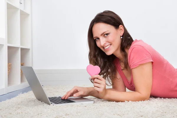 Frau liegt auf dem Boden vor Laptop — Stockfoto