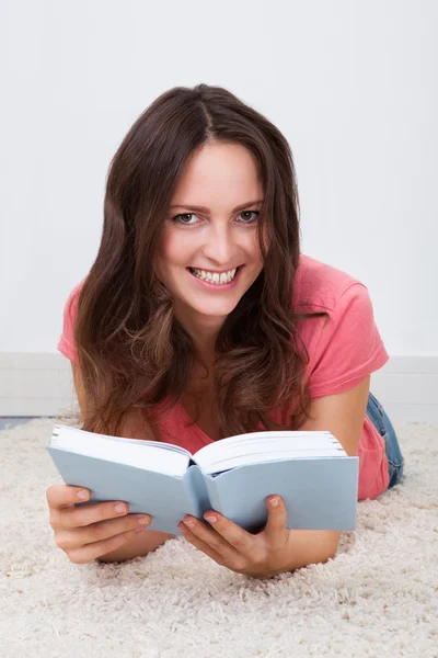 Ung kvinna läser bok — Stockfoto