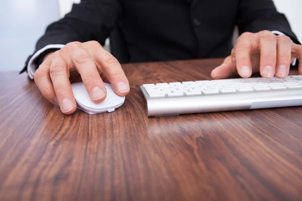 Affärsmannens hand använder dator på skrivbordet — Stockfoto