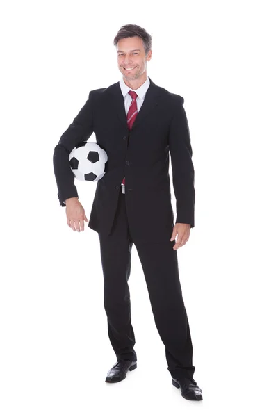 Бизнесмен, проводящий футбол — стоковое фото