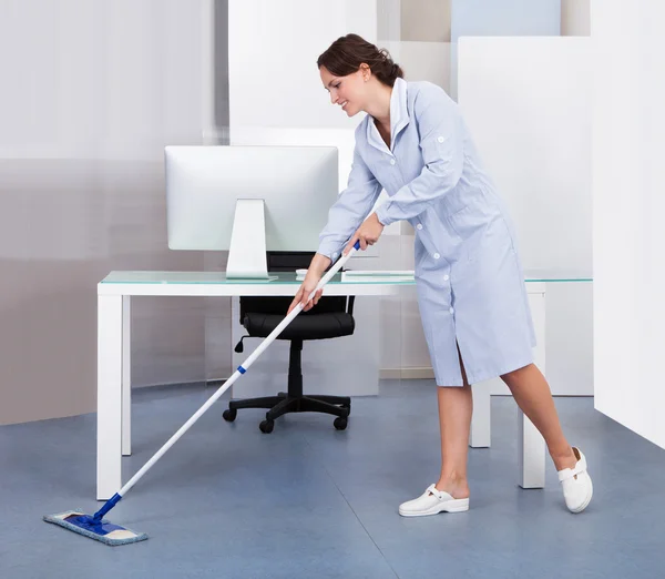 Služka úklid podlahy v úřadu — Stock fotografie