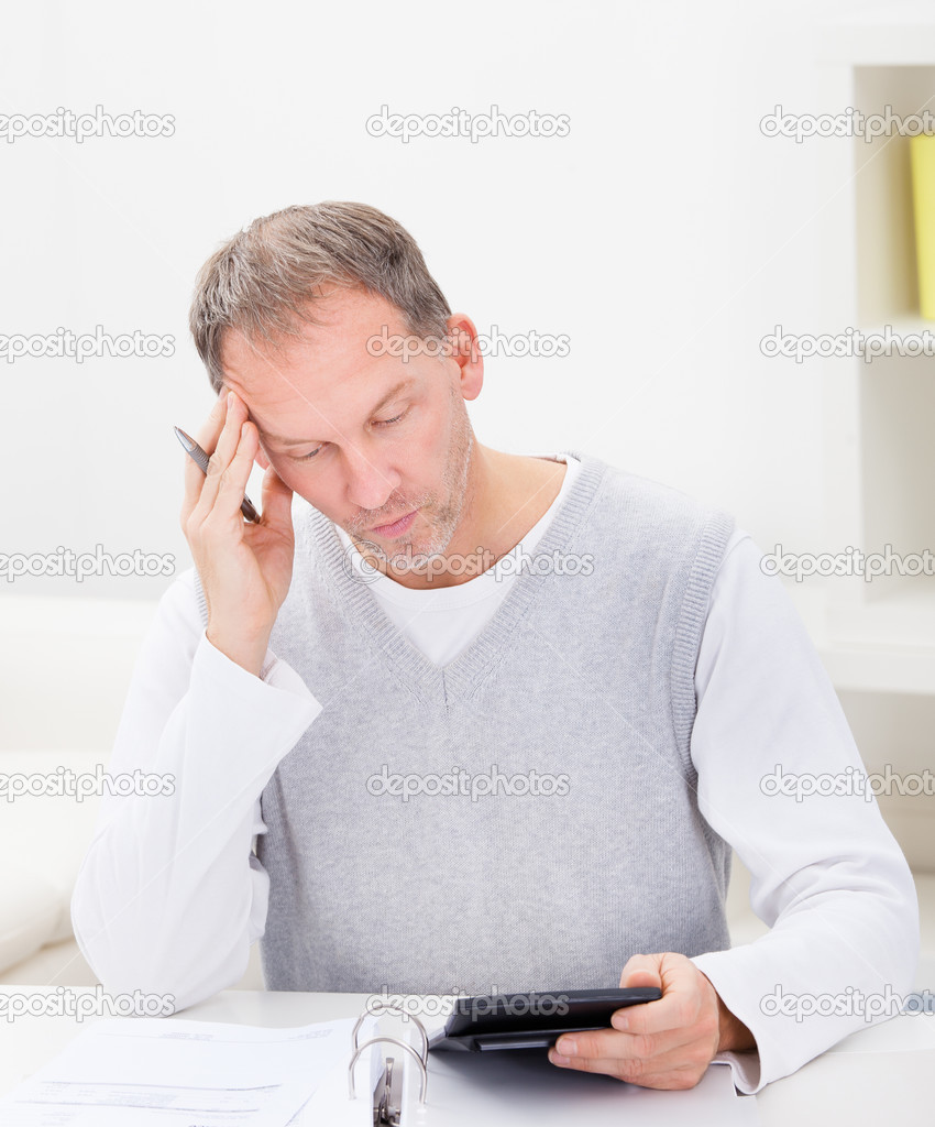 Thoughtful Man Holding Calculator