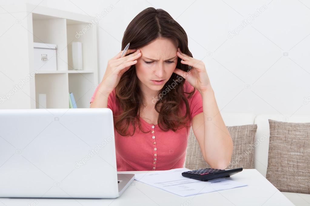 Worried Young Woman Doing Calculations